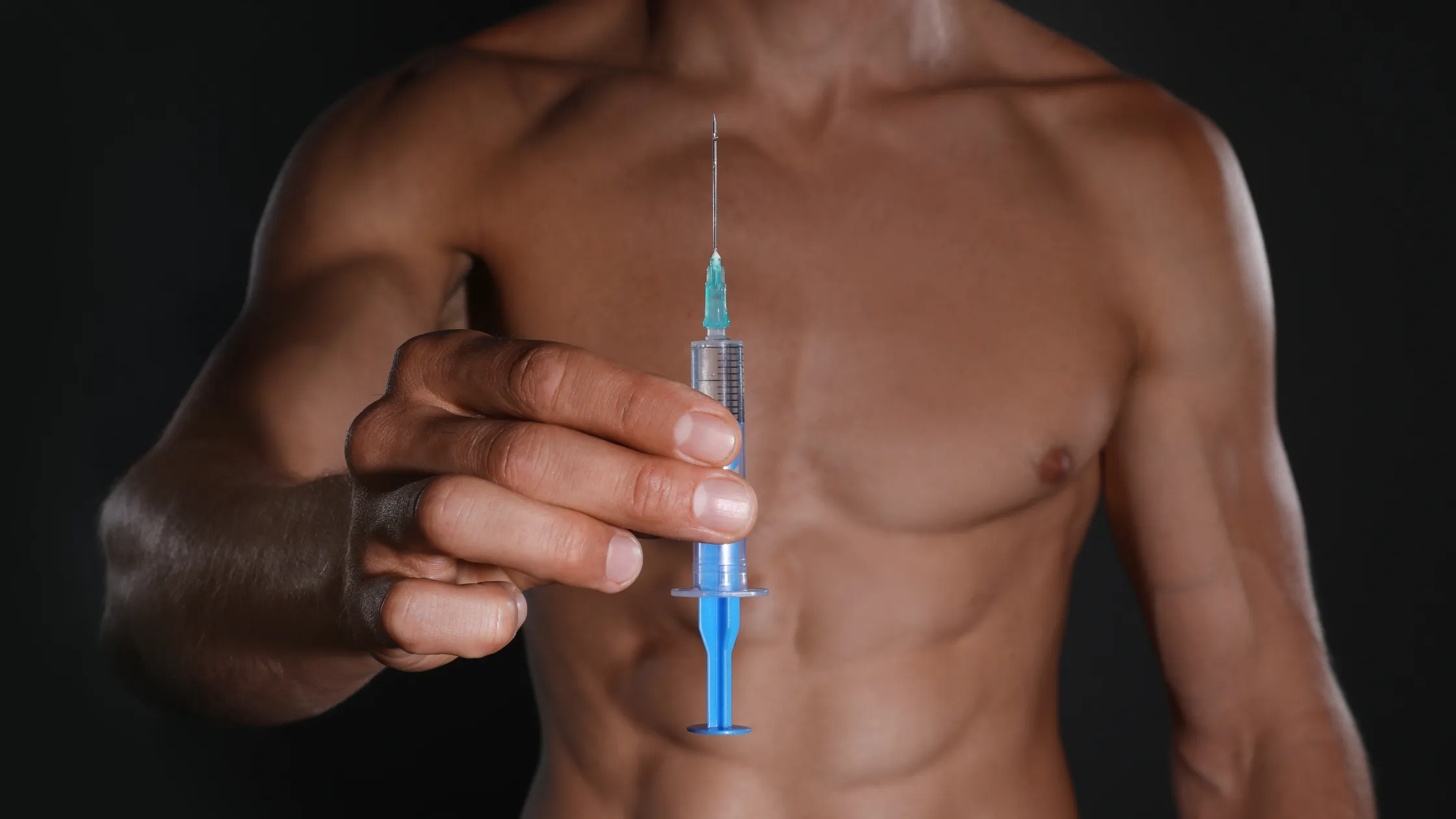 ドーピングらしき薬を保持している筋肉質の男性